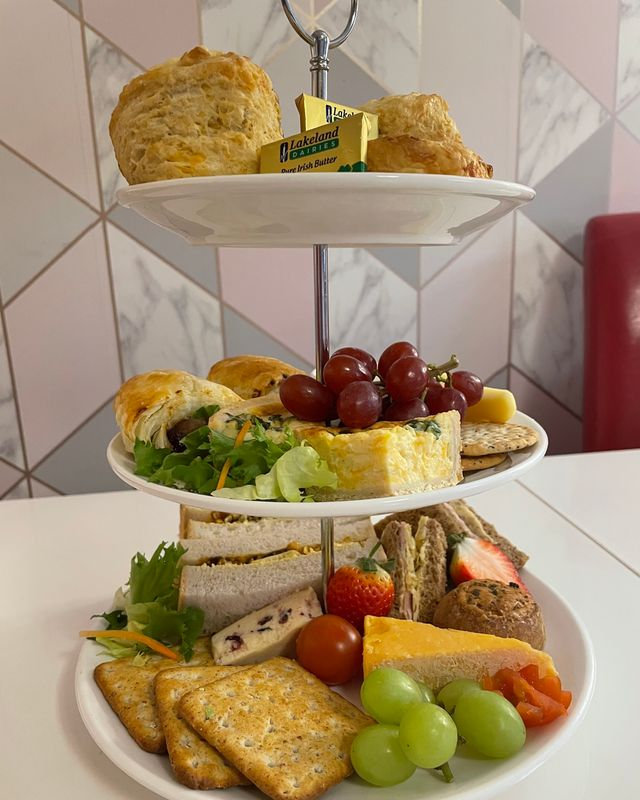 Three-tier afternoon tea stand with scones, sandwiches and cakes